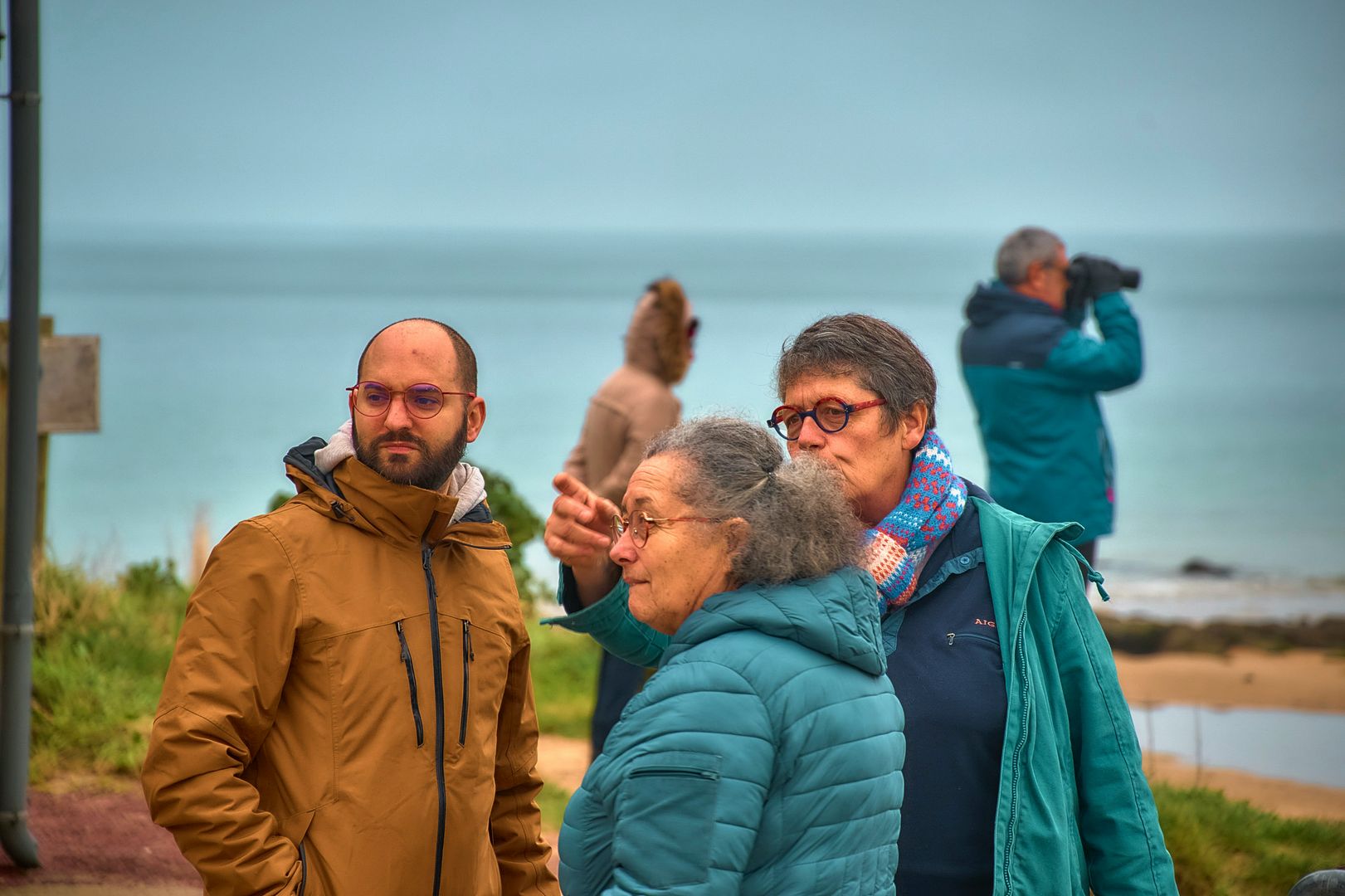 a group of people by the shore bird watching