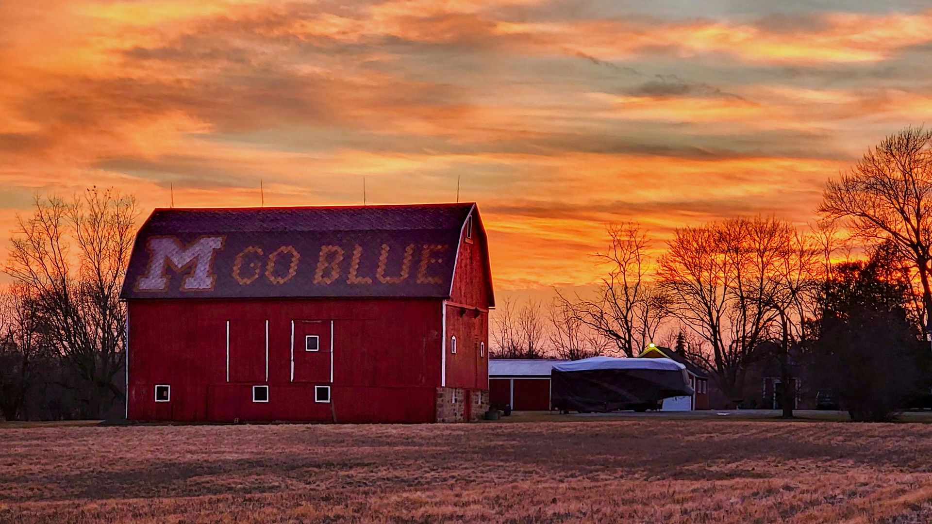 A red barn with M Go Blue painted on the roof